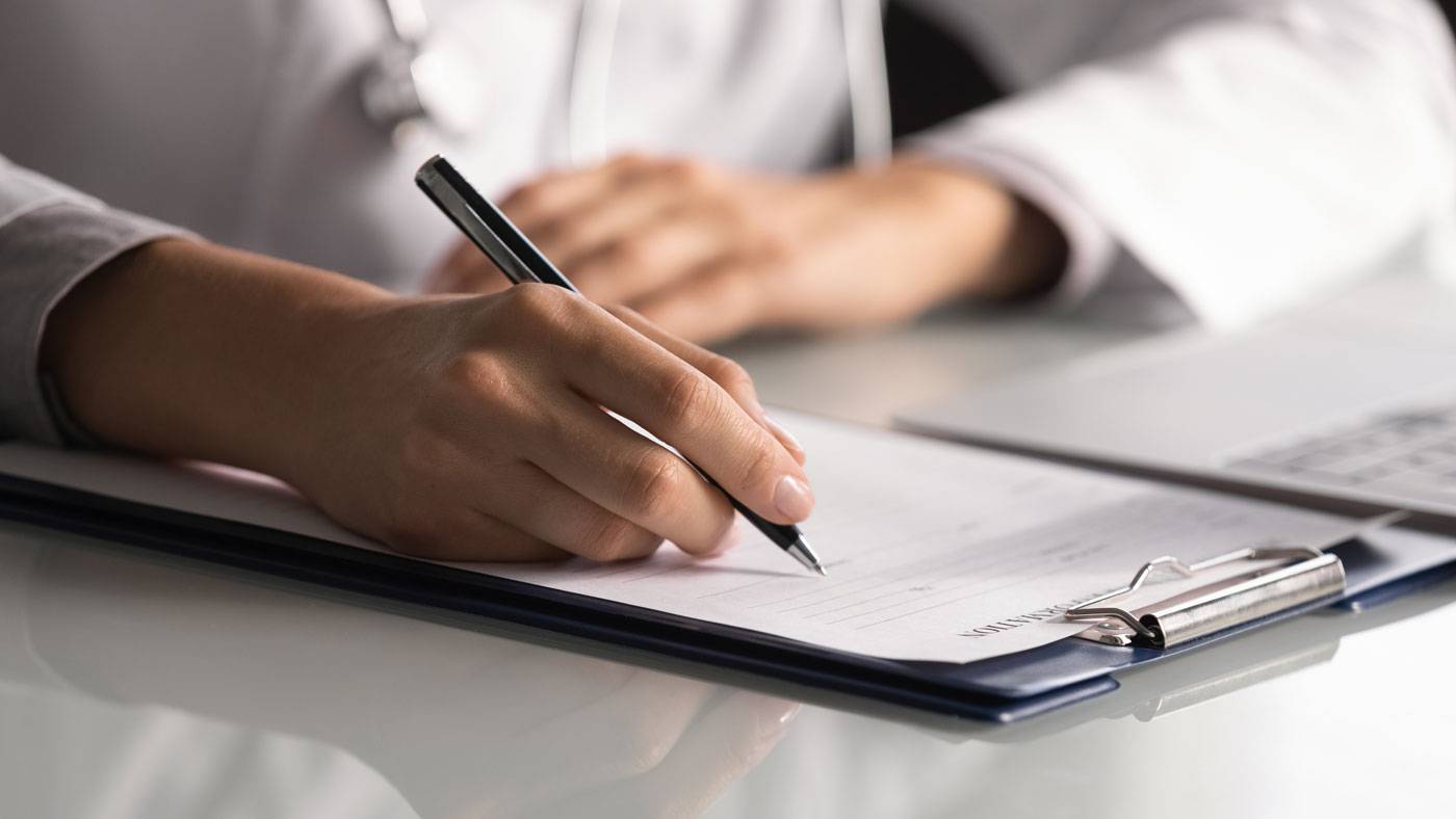 Business-writing-hand-holding-pen-writes-on-clipboard.jpg
